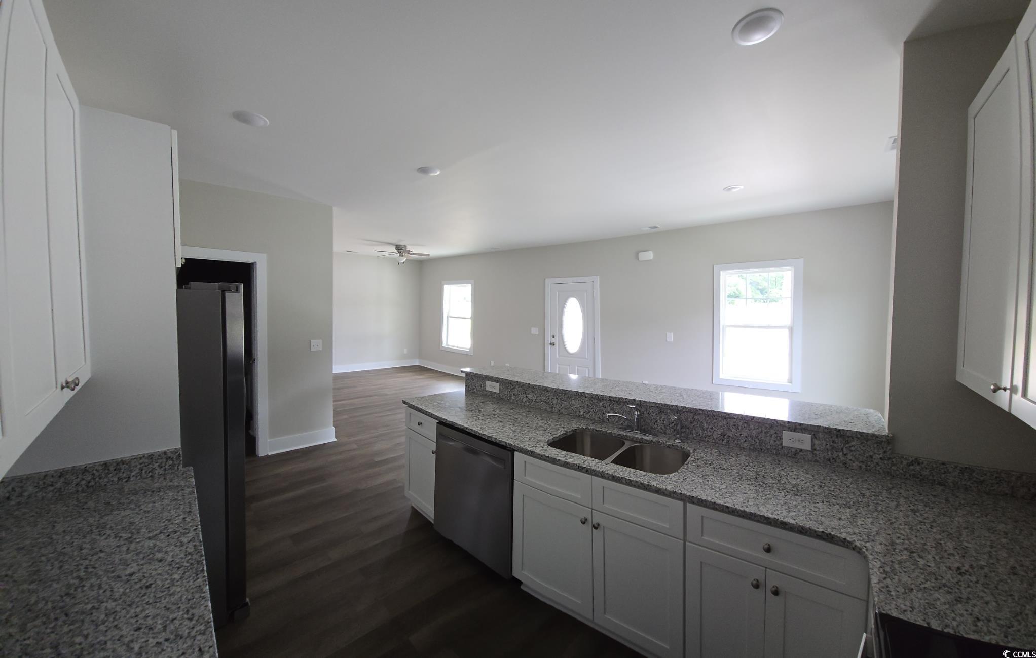 4890 Highway 319 Aynor, SC 29511 - Photo 12 of 21 Kitchen with white cabinets, a peninsula, dark wood-style floors, light stone counters, and a ceiling fan