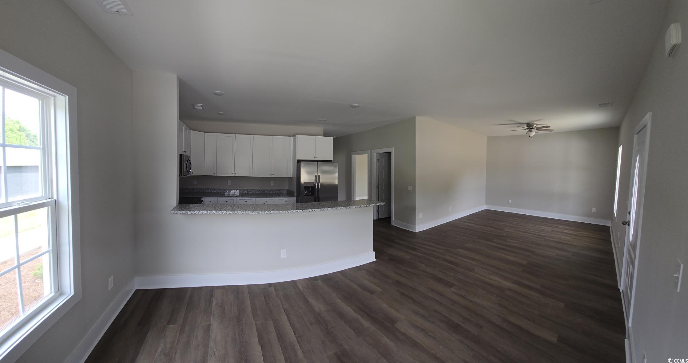 4890 Highway 319 Aynor, SC 29511 - Photo 13 of 21 Kitchen featuring white cabinets, a peninsula, dark wood-style floors, appliances with stainless steel finishes, and light stone counters