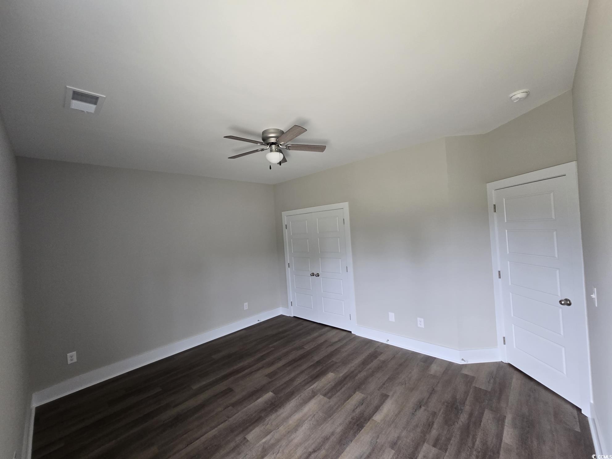 4890 Highway 319 Aynor, SC 29511 - Photo 15 of 21 Unfurnished bedroom featuring dark wood-style flooring, a ceiling fan, and a closet