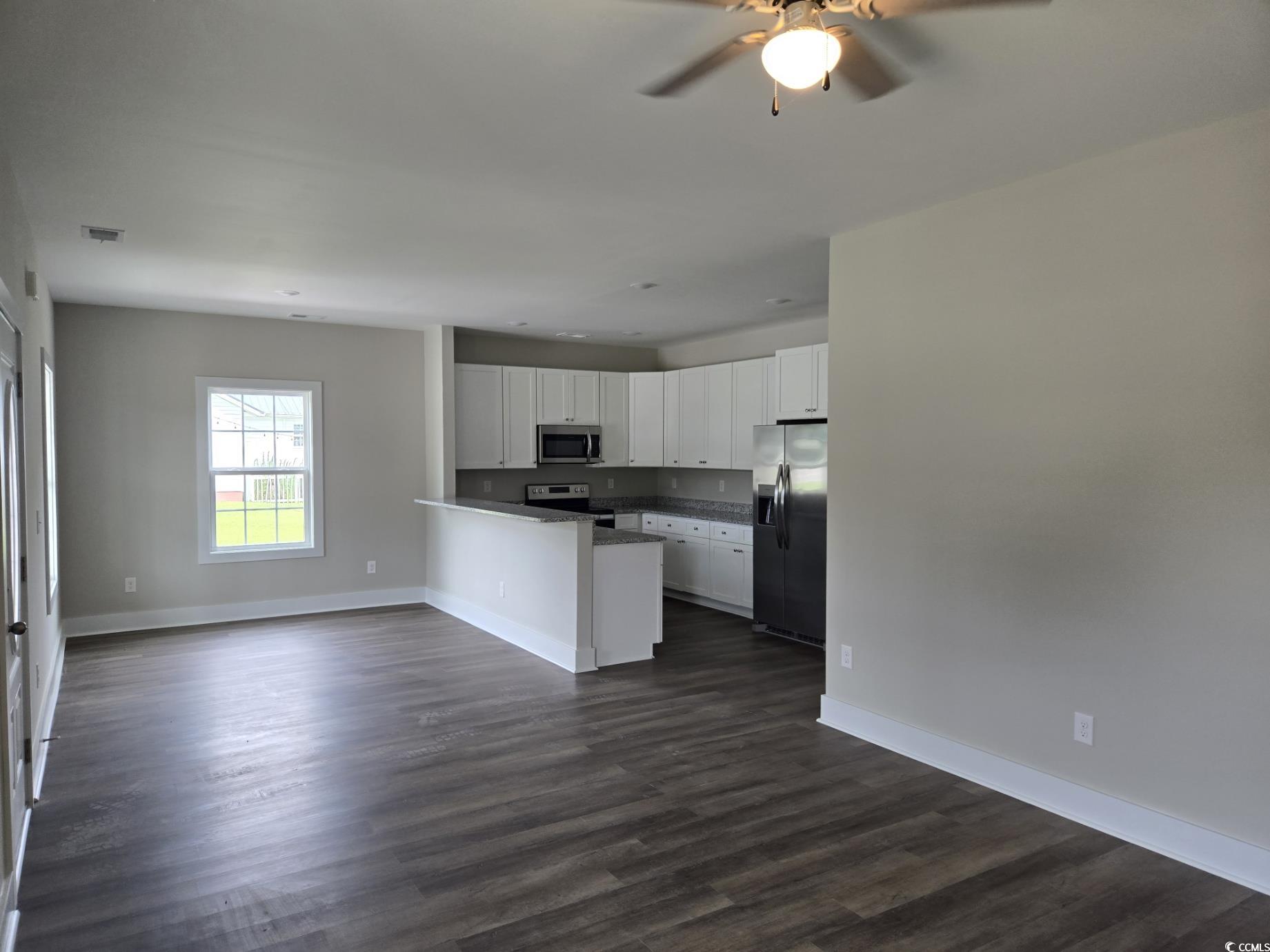 4890 Highway 319 Aynor, SC 29511 - Photo 20 of 21 Kitchen featuring open floor plan, white cabinetry, stainless steel appliances, a peninsula, and dark wood finished floors