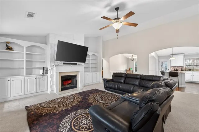 a living room with furniture a chandelier and a rug
