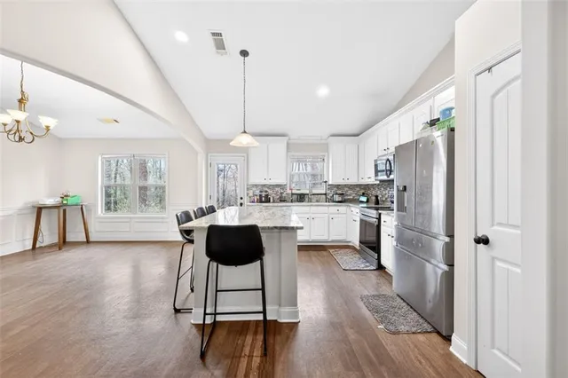 a kitchen with appliances cabinets and chairs
