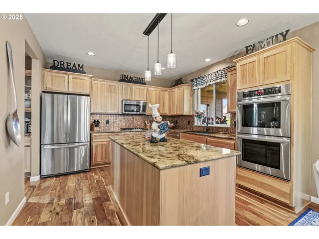 a kitchen with stainless steel appliances granite countertop a refrigerator a stove a sink and a refrigerator