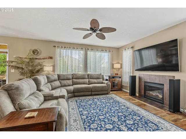 a living room with furniture a flat screen tv and a fireplace