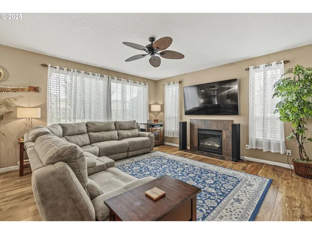 a living room with furniture a flat screen tv and a fireplace