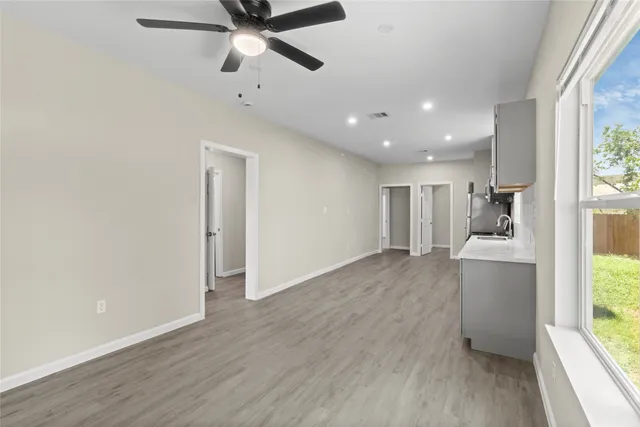 a view of empty room with wooden floor and window