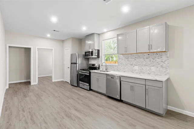 a kitchen with granite countertop white cabinets and stainless steel appliances