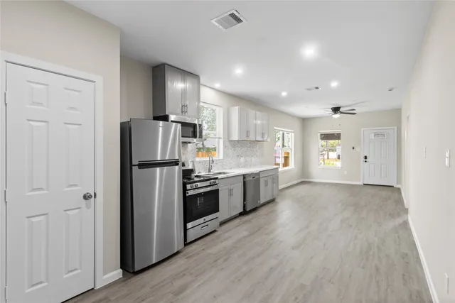 a kitchen with a refrigerator a sink and a stove top oven