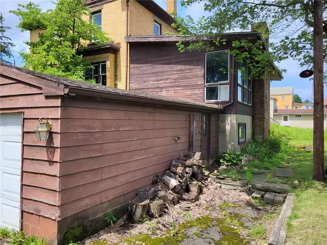 a view of a house with a yard and potted plants