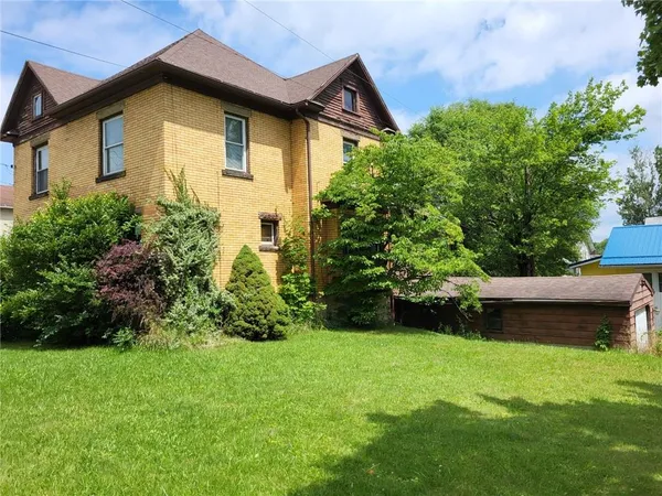 a view of a house with a yard and sitting area
