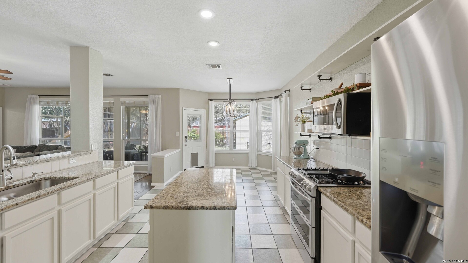 4520 Ridge Peak Drive Schertz, TX 78154 - Photo 5 of 44 a large white kitchen with stainless steel appliances granite countertop a stove and a refrigerator