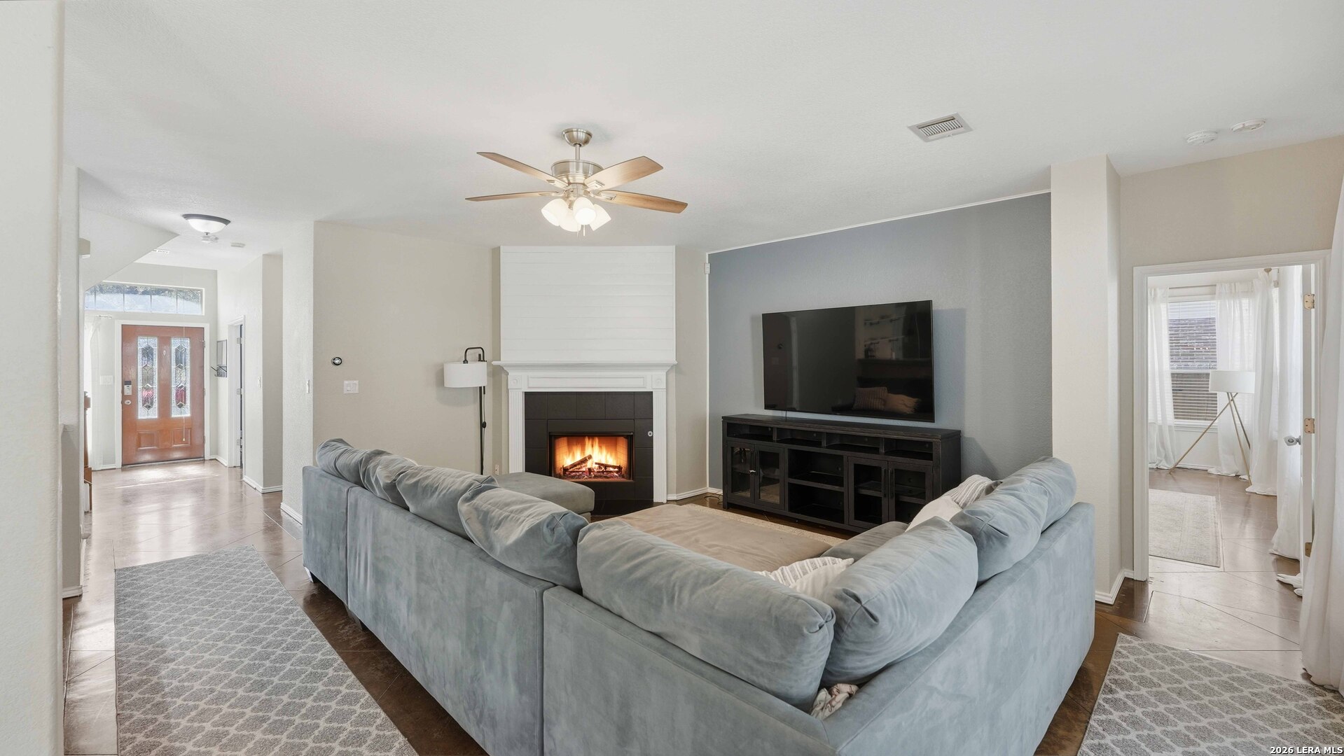 4520 Ridge Peak Drive Schertz, TX 78154 - Photo 10 of 44 a living room with furniture a flat screen tv and a fireplace