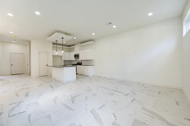 a view of kitchen with white cabinets and refrigerator