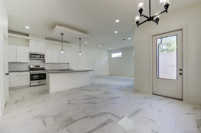 a view of kitchen with sink and refrigerator