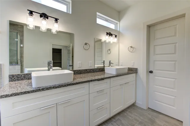 a bathroom with a granite countertop sink double and mirror