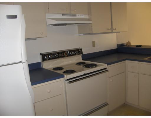 1950 Southwest Palm City Road, Unit 9104 Stuart, FL 34994 - Photo 4 of 8 a kitchen with a stove and a refrigerator
