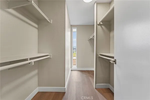 a view of walk in closet with empty racks
