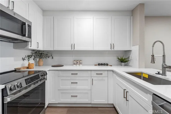 a kitchen with stainless steel appliances granite countertop a sink a stove and cabinets