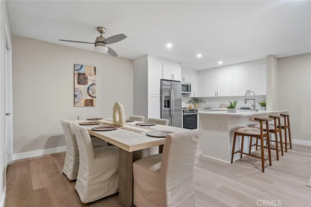 a open dining room with stainless steel appliances kitchen island a table and chairs