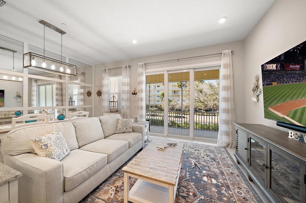 2516 Coral Court Indian Rocks Beach, FL 33785 - Photo 12 of 69 a living room with furniture a flat screen tv and a floor to ceiling window