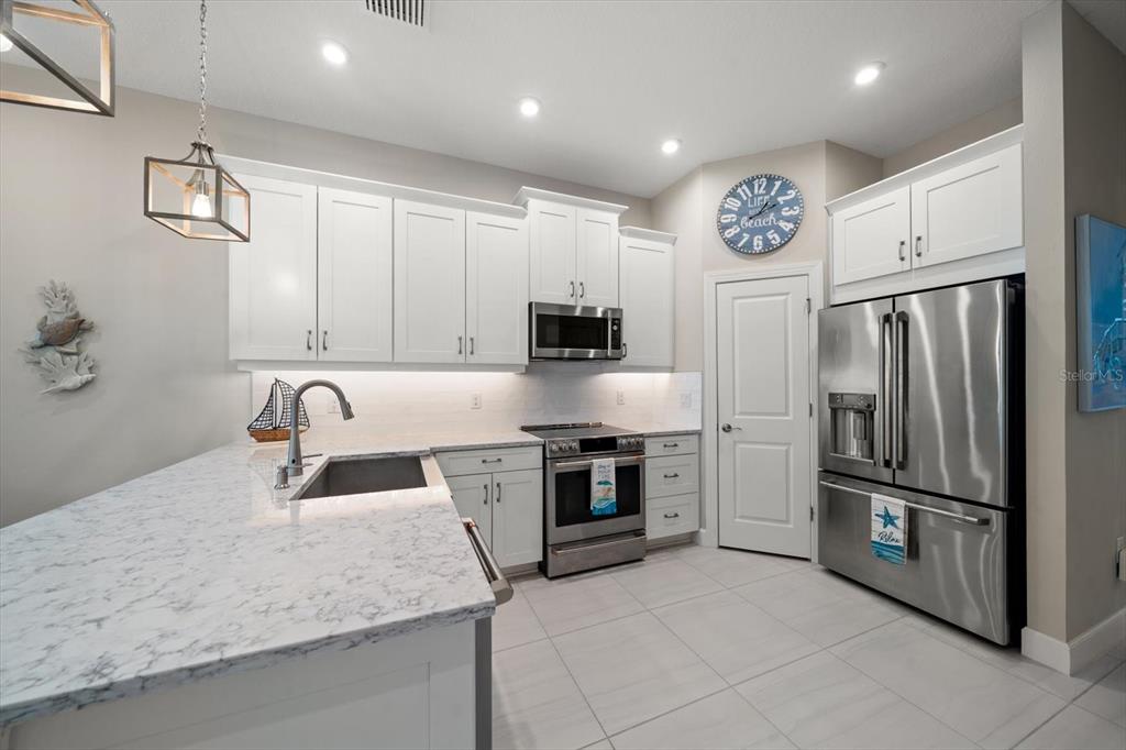 2516 Coral Court Indian Rocks Beach, FL 33785 - Photo 34 of 69 a kitchen with stainless steel appliances granite countertop a refrigerator and a sink