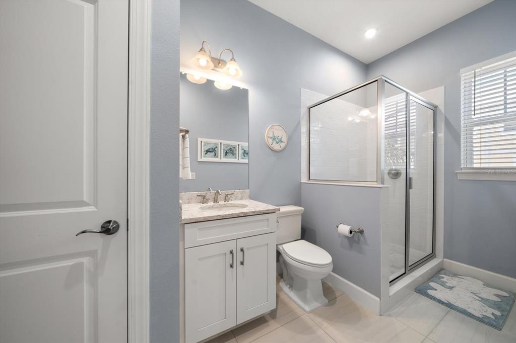 2516 Coral Court Indian Rocks Beach, FL 33785 - Photo 40 of 69 a bathroom with a granite countertop sink toilet a mirror a vanity and shower