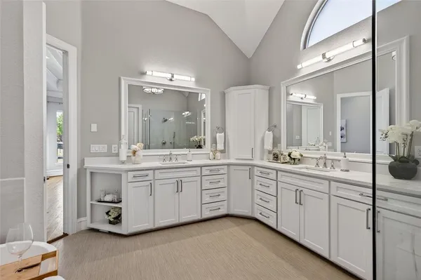 a large bathroom with a double vanity sink and mirror with shower