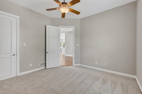 an empty room with closet and a chandelier fan