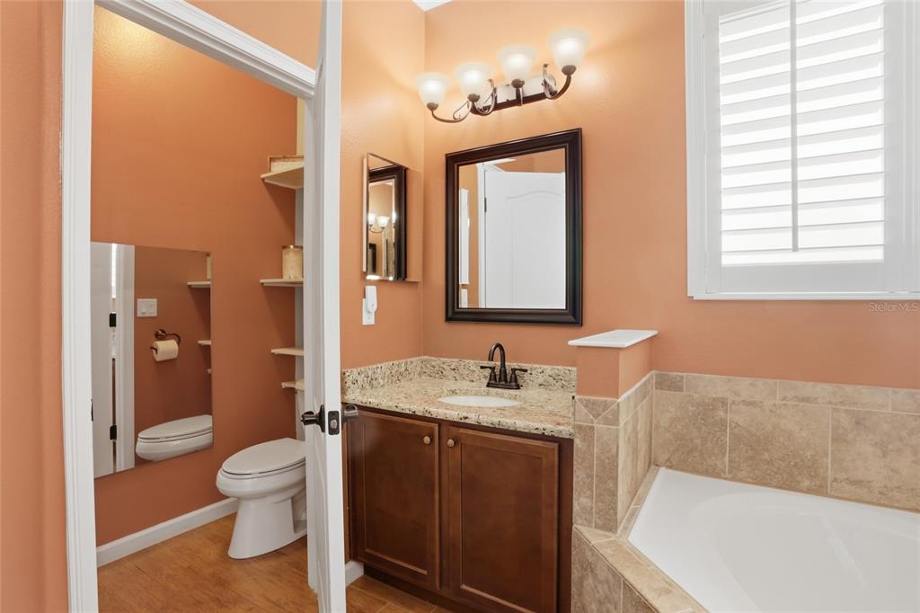 877 Haring Lane Mount Dora, FL 32757 - Photo 9 of 26 a bathroom with a granite countertop sink toilet and shower
