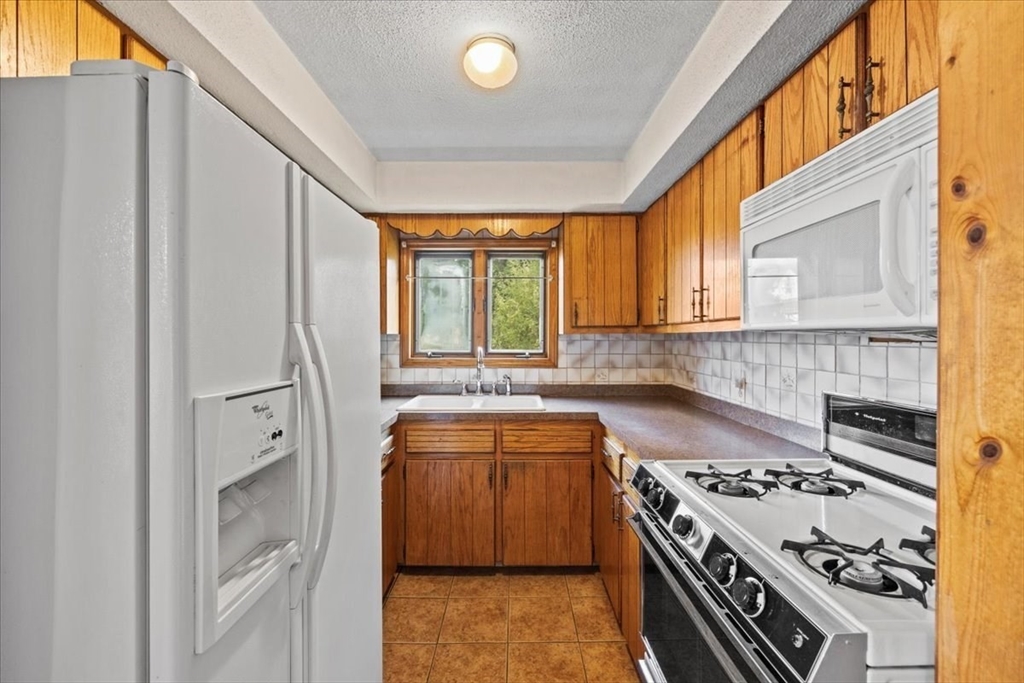 14 Grinnell Street Fall River, MA 02721 - Photo 15 of 41 a kitchen with stainless steel appliances granite countertop a stove and a refrigerator
