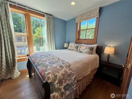 a bedroom with a bed and a lamp next to a window