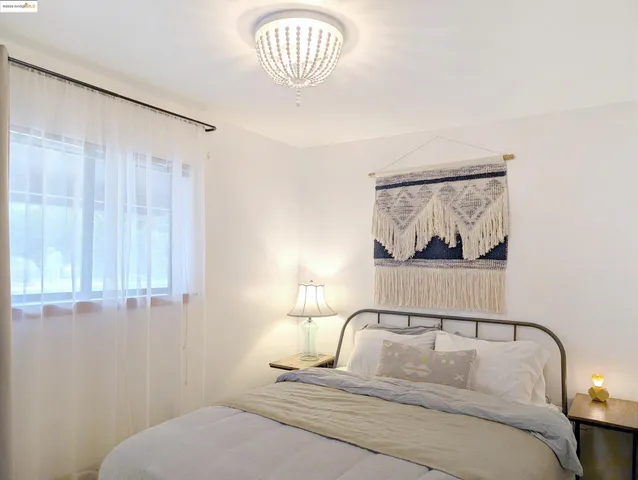 a bedroom with a bed and a painting on the wall