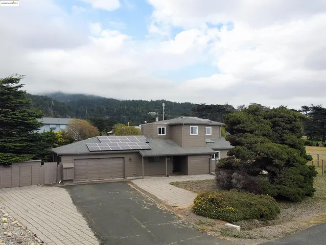 an aerial view of a house with swimming pool and mountains
