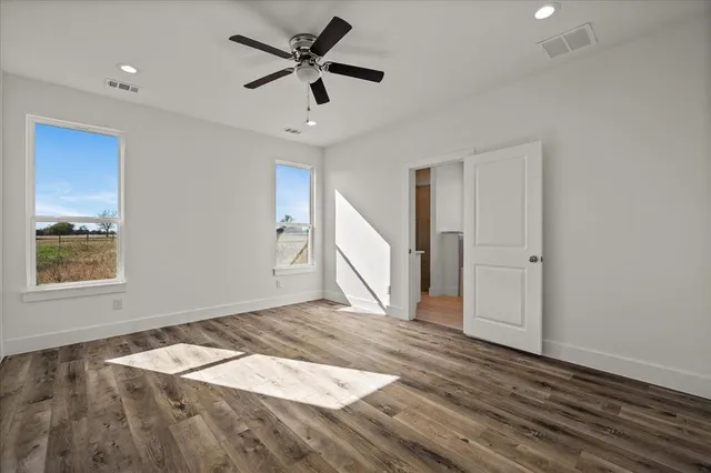 a view of empty room with wooden floor and window