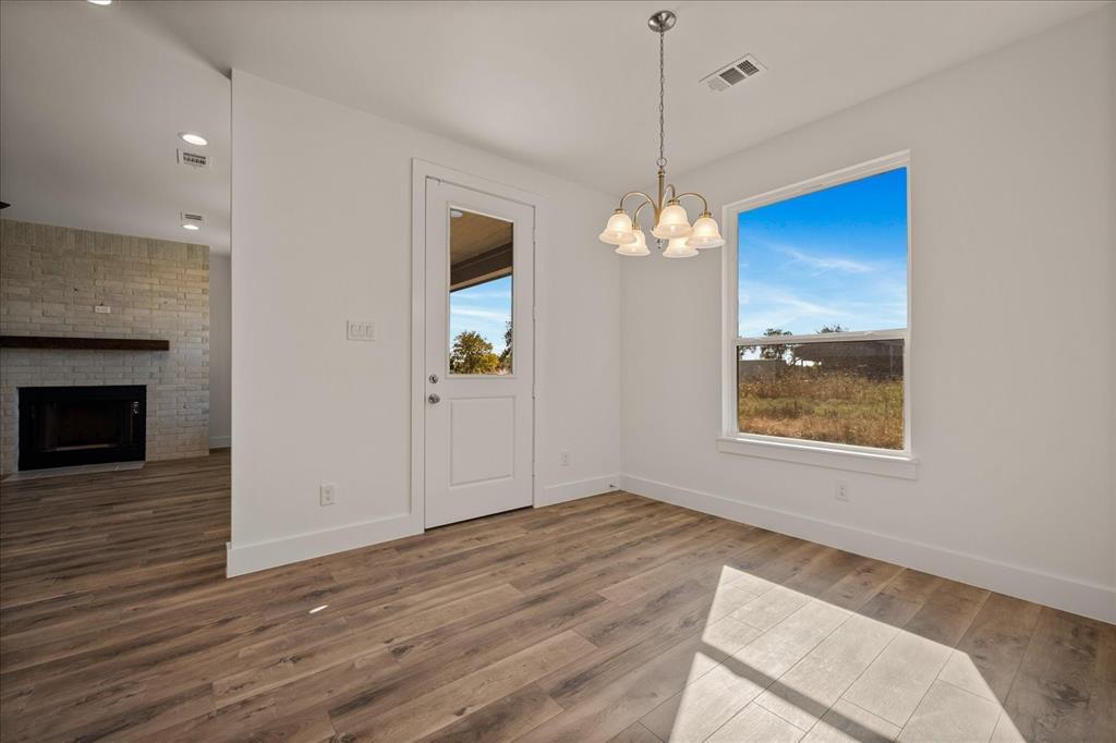 3232 Willow Road Celeste, TX 75423 - Photo 19 of 31 a view of an empty room with wooden floor fireplace and a window