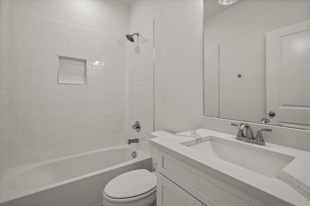 3232 Willow Road Celeste, TX 75423 - Photo 21 of 31 a bathroom with a granite countertop sink toilet a mirror and bathtub