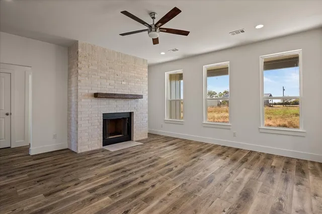 an empty room with windows and fireplace