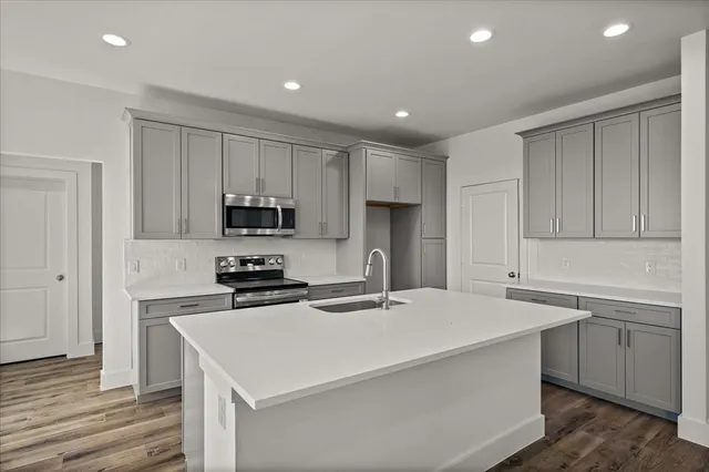 a kitchen with a sink a stove a refrigerator and cabinets