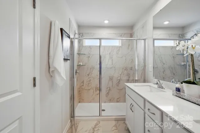 a bathroom with a shower sink and mirror