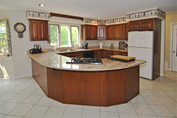 34 Grey Rock Road Bedford, NH 03110 - Photo 7 of 27 a kitchen with granite countertop a sink a stove and a refrigerator