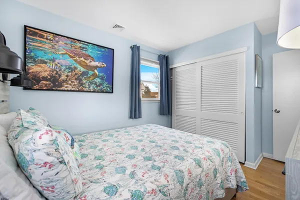 a bedroom with a bed and a painting on the wall