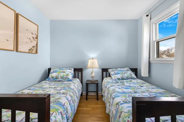a bedroom with two beds and a window