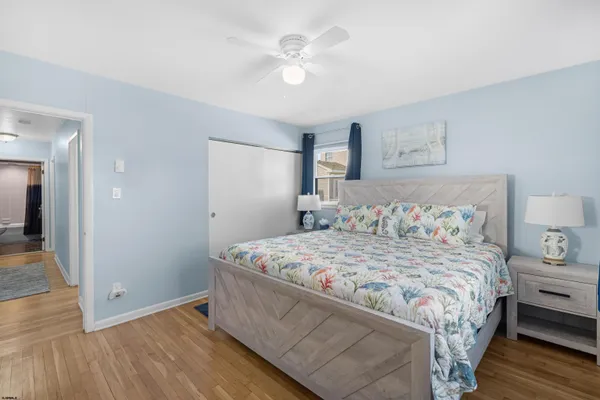 a bedroom with a large bed and wooden floor