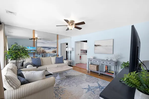 a living room with furniture a flat screen tv and a potted plant