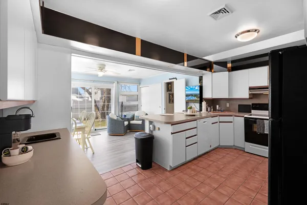 a kitchen with white cabinets and appliances