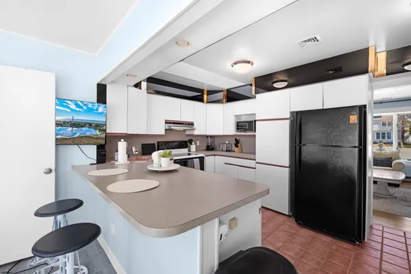 a kitchen with stainless steel appliances granite countertop a sink a stove a refrigerator and a refrigerator