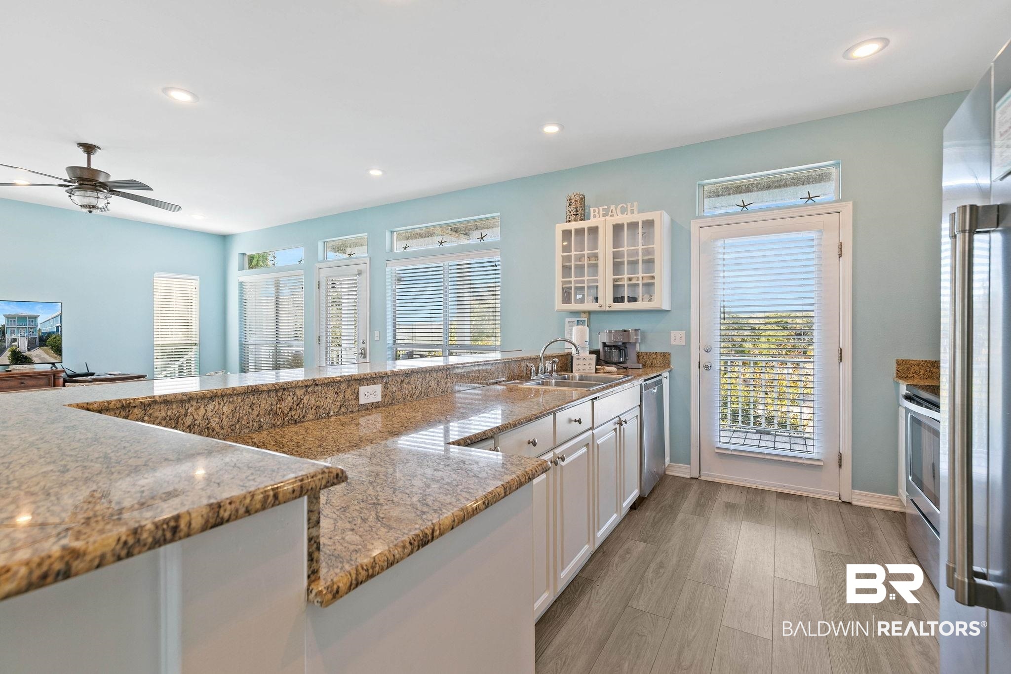 545 Plantation Road, Unit 3 Gulf Shores, AL 36542 - Photo 14 of 54 Kitchen featuring glass insert cabinets, recessed lighting, white cabinetry, light wood-style flooring, and appliances with stainless steel finishes