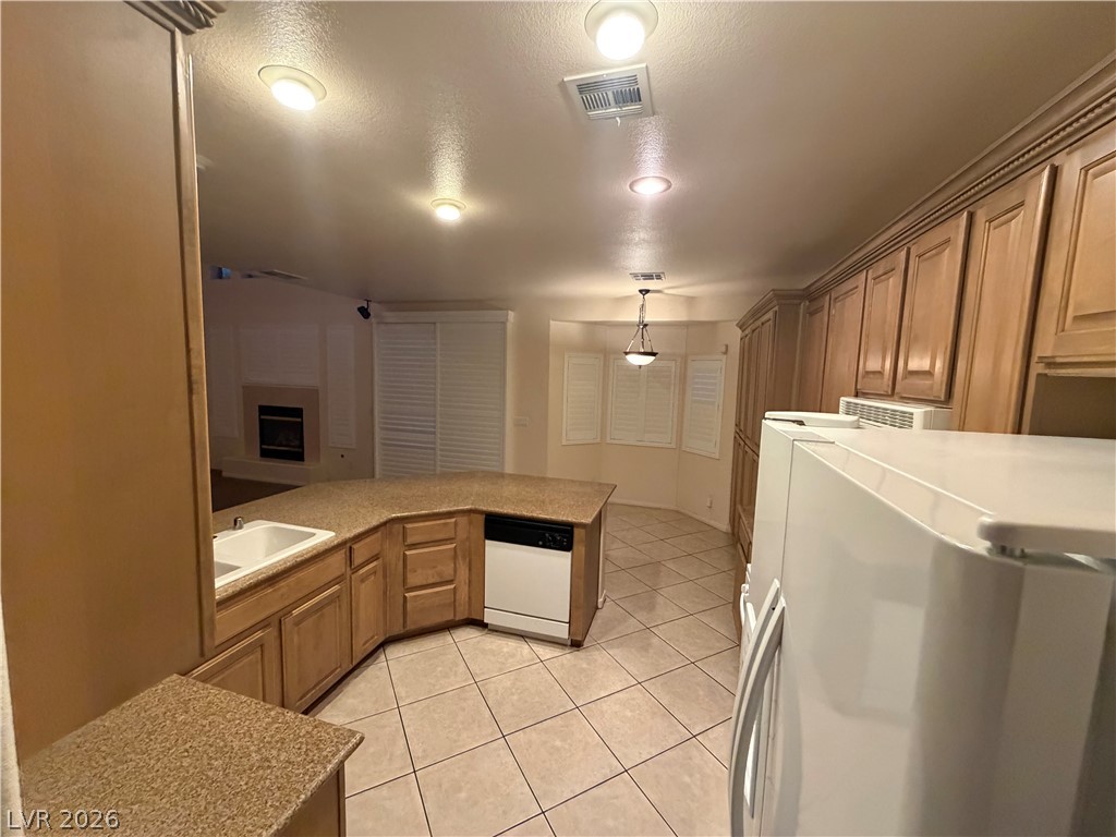 7629 Rory Court Las Vegas, NV 89129 - Photo 4 of 25 Functional kitchen with ample cabinetry and a practical island, connecting seamlessly to adjacent living areas.
