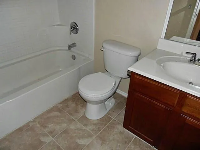 a white toilet sitting next to a bath tub