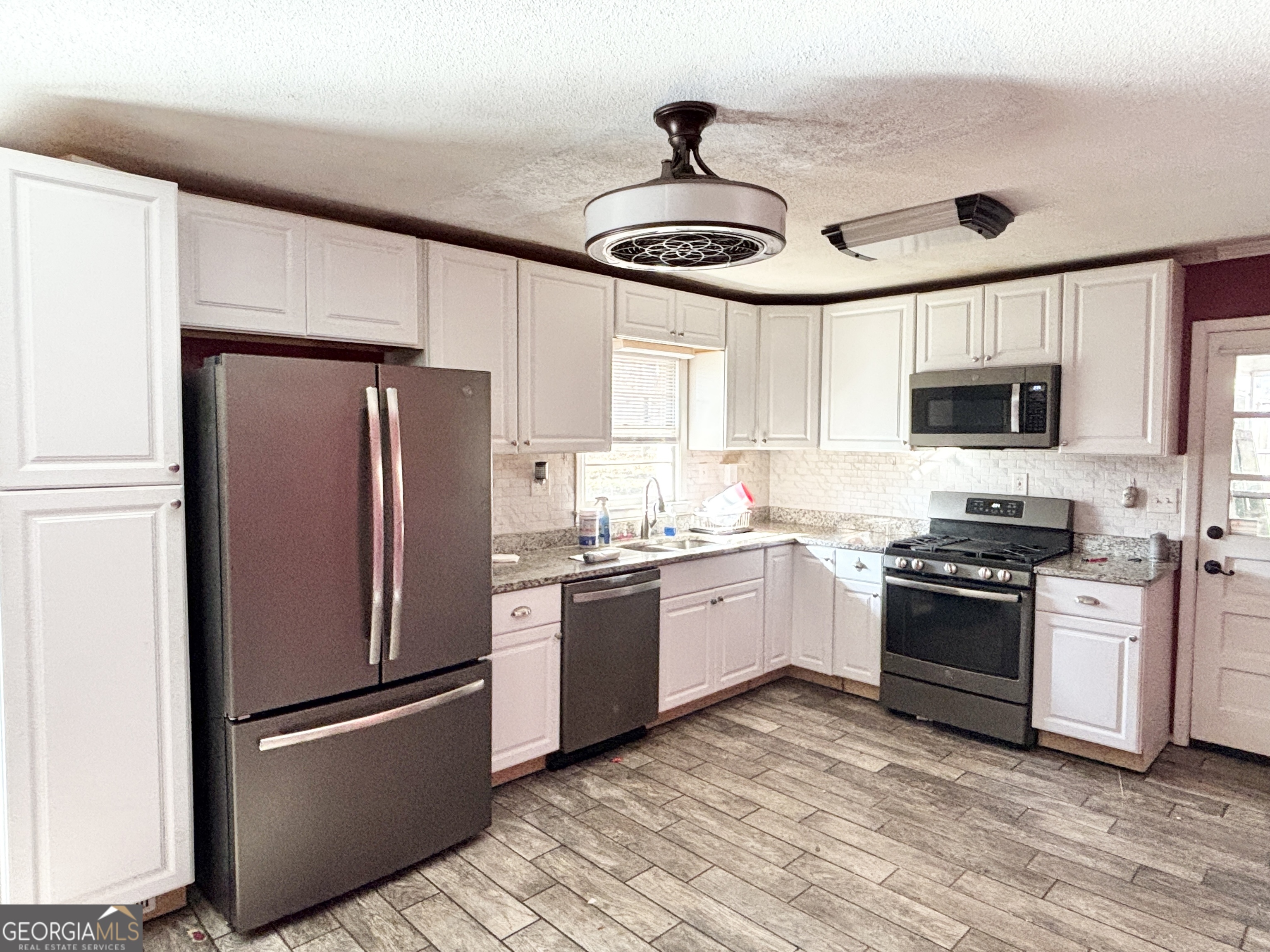 210 Arrowhead Road Athens, GA 30606 - Photo 3 of 15 a kitchen with stainless steel appliances granite countertop a refrigerator a stove a sink and a microwave
